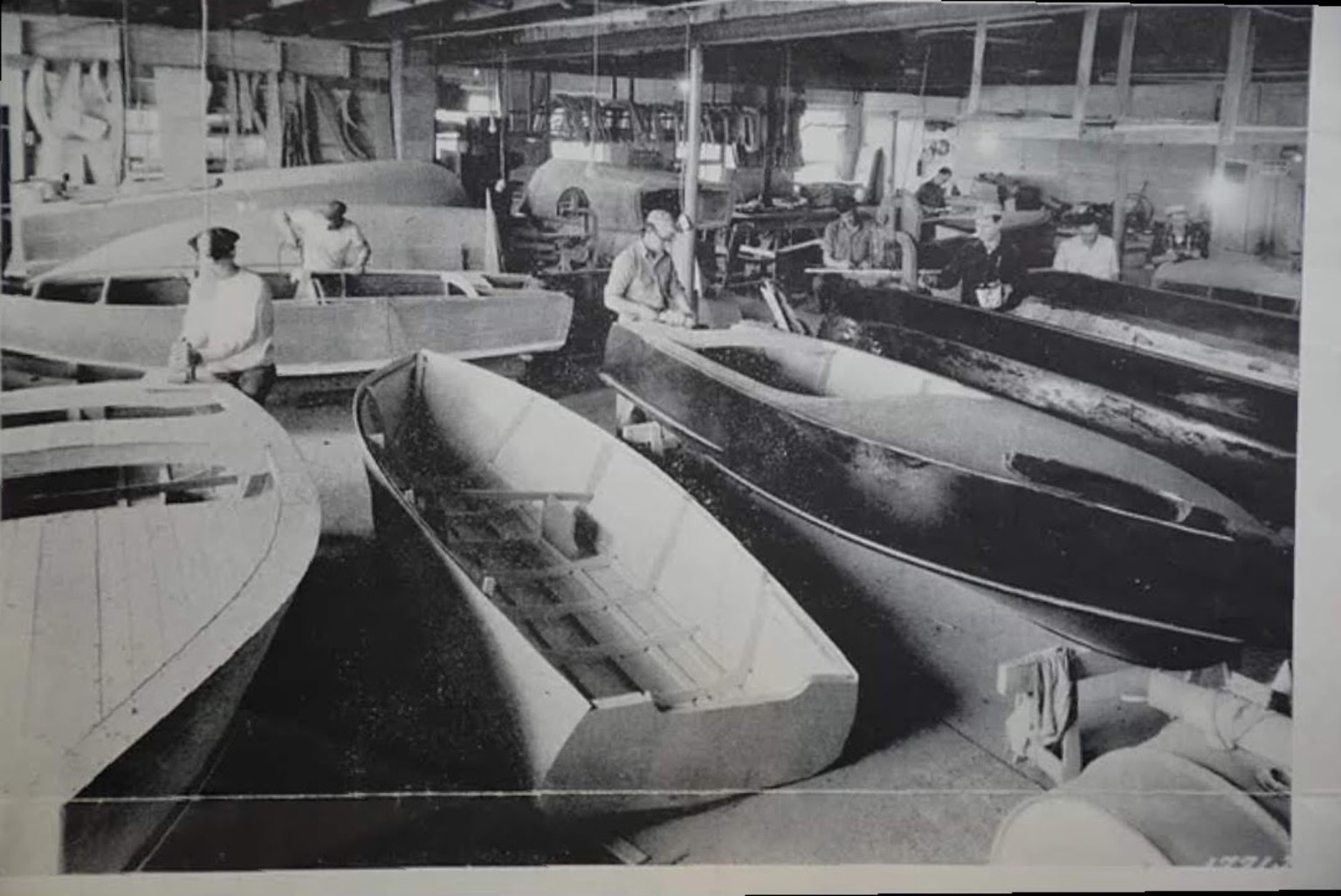 Craftsmen building wooden boats inside the Northwestern shop
